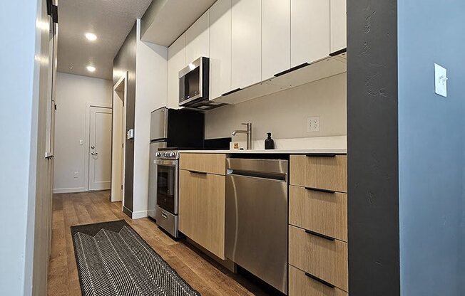 A kitchen with a black fridge and white cabinets.