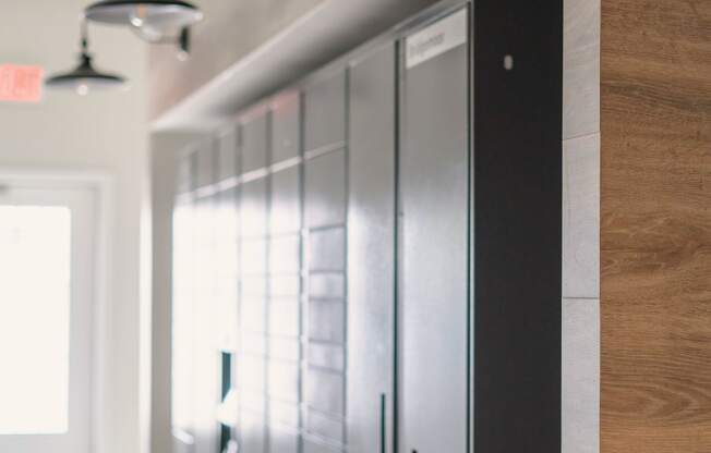 a view down a hallway with a row of lockers on the left and three lights on