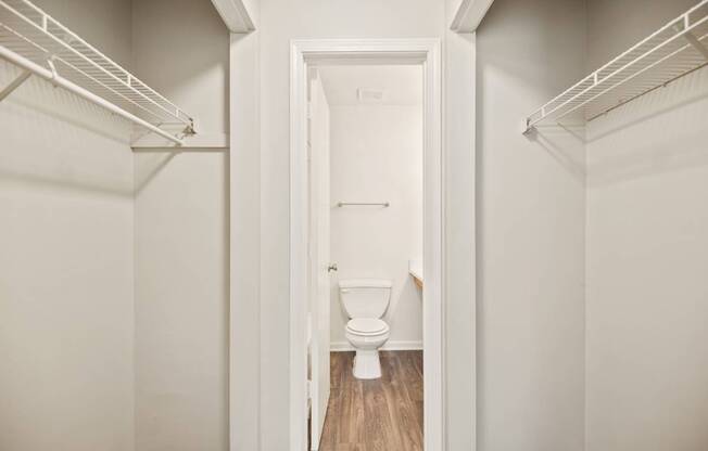 A white toilet is in the doorway of a white room.