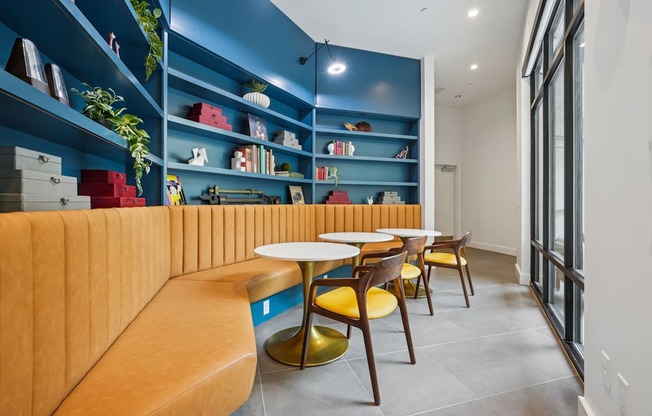 A room with a blue wall and a yellow couch.