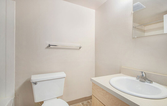 a studio bathroom with a sink toilet and a mirror at Old Farm Apartments, Elkhart, Indiana