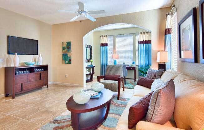 A living room with a tan couch and a wooden coffee table.