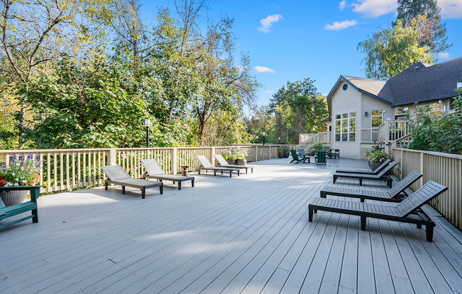 A deck with benches and a house in the background.
