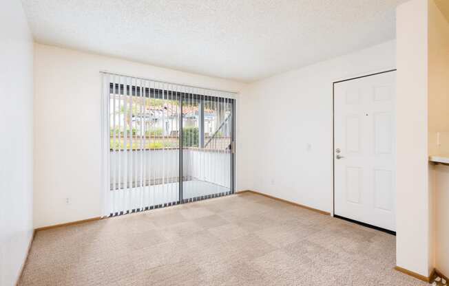 a bedroom with a large window and beige carpet