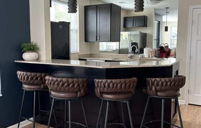 a kitchen with a counter top and some chairs
