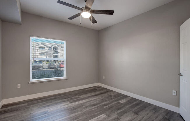 a bedroom with hardwood floors and a ceiling fan