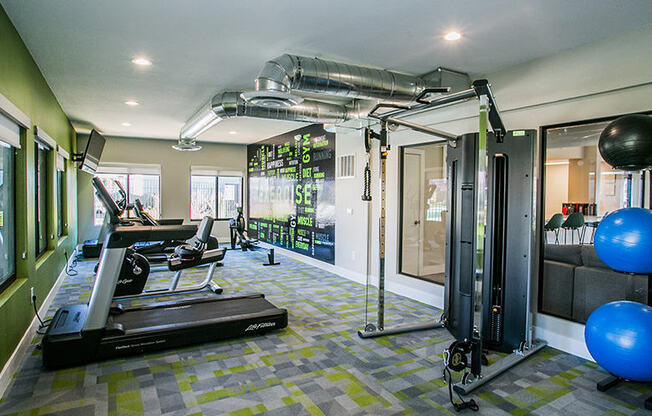 a home gym with a treadmill and weights on the floor