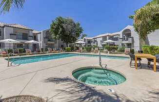 Dive into relaxation in our pool oasis with a hot tub and shaded lounging area at Boulders at Lookout Mountain Apartment Homes, Phoenix, AZ