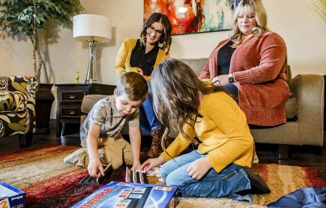 A family playing a board game in a living room at Legends of River Oaks