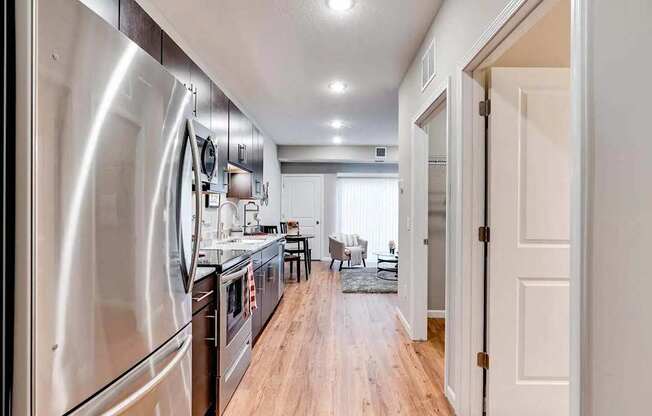 a kitchen with stainless steel appliances and a door to a living room. Circle Pines, MN Lexington Lofts