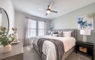 a bedroom with a large bed and a ceiling fan