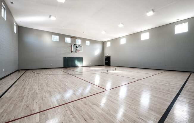 the inside of an empty gym with a basketball court