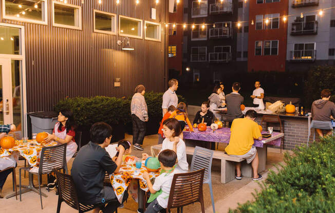 a group of people sitting at a table in front of a building