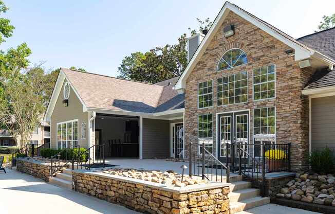 A house with a stone wall and a black fence.