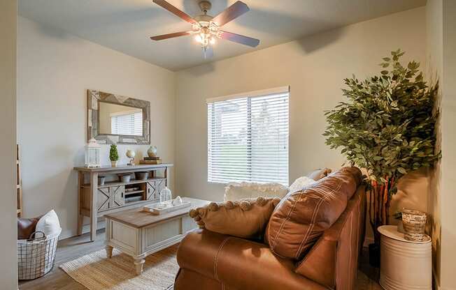 a living room with a ceiling fan and a large window