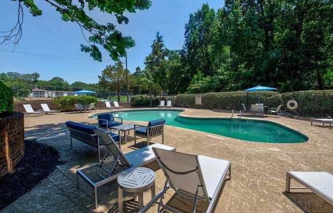 a swimming pool with chairs and tables next to it