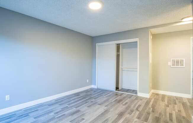 an empty living room with blue walls and a door to a closet