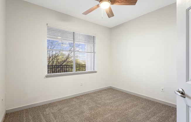 an empty room with a large window and a ceiling fan at The Legends at Eagle Mountain Lake, Fort Worth, TX, 76179