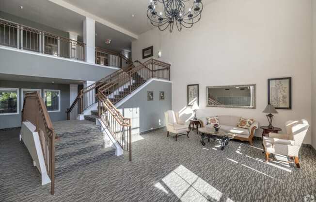 A large, open-concept living room with a staircase and a chandelier.