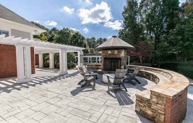 a patio with a stone fireplace and patio furniture at Roswell Village, Roswell, 30075