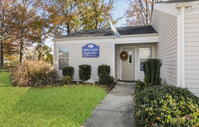 a white building with a white door and a blue sign on it