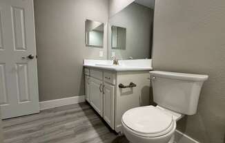 A white toilet sits next to a sink in a bathroom.