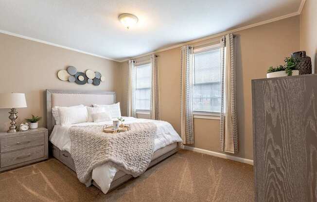 A bedroom with a large bed and a nightstand with a lamp.