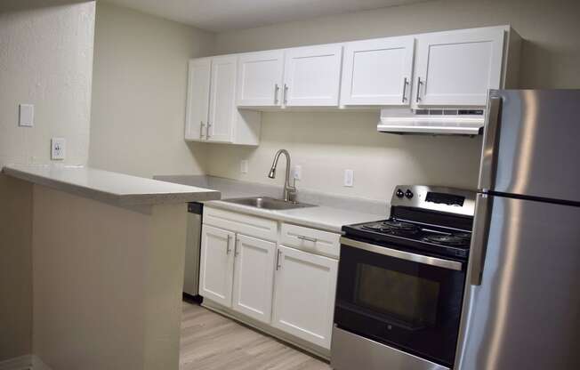 a kitchen with stainless steel appliances and white cabinets