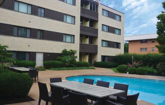 Poolside table and chairs are set up outside a building.