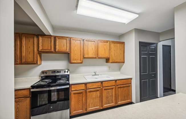 a kitchen with wooden cabinets and black appliances and a sink