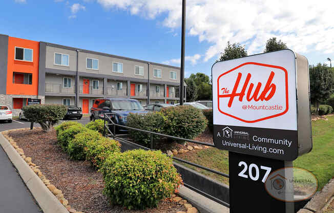 A sign in front of the apartment building that reads The Hub @ Mountcastle.