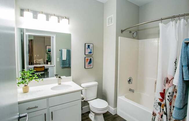 A white bathroom with a toilet, sink, and bathtub. at Octave Apartments, Las Vegas, NV, 89123