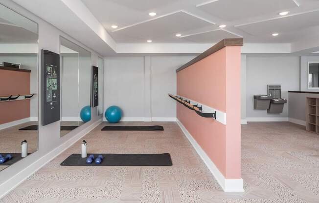 A room with a mirror, exercise balls, and yoga mats.