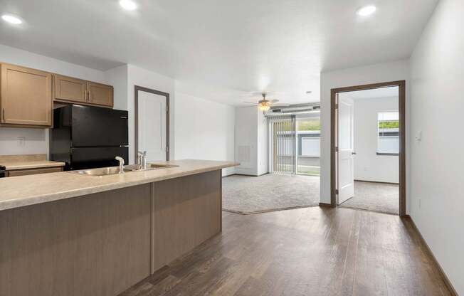 A kitchen with wooden cabinets and a black fridge.