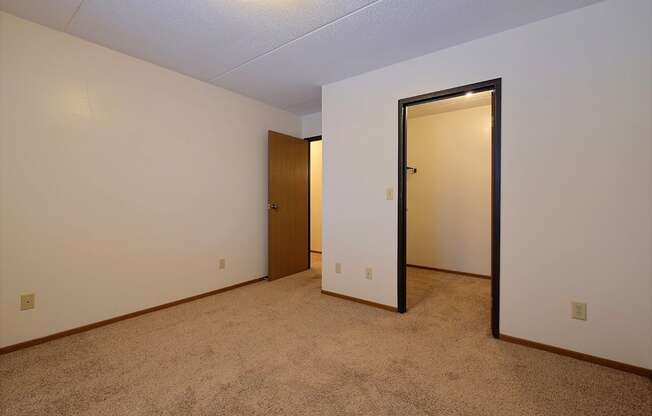 a bedroom with a door to a closet and a carpeted floor at France, Fargo