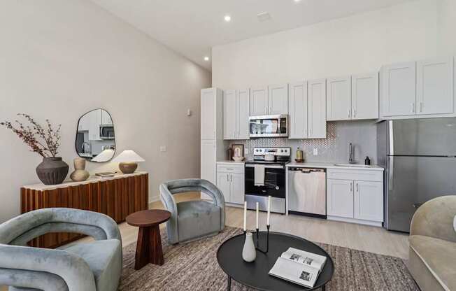 A modern living room with a grey sofa, a coffee table, and a kitchen in the background.
