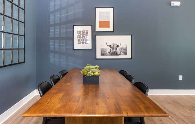 a conference room with a wooden table and chairs and pictures on the wall
