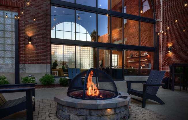 A fire pit sits in the middle of a brick courtyard.