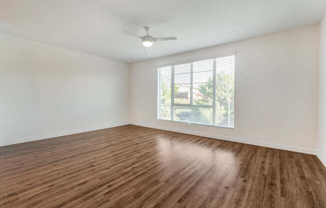 an empty living room with a window and wood flooring at Metro Gateway, Riverside, 92503