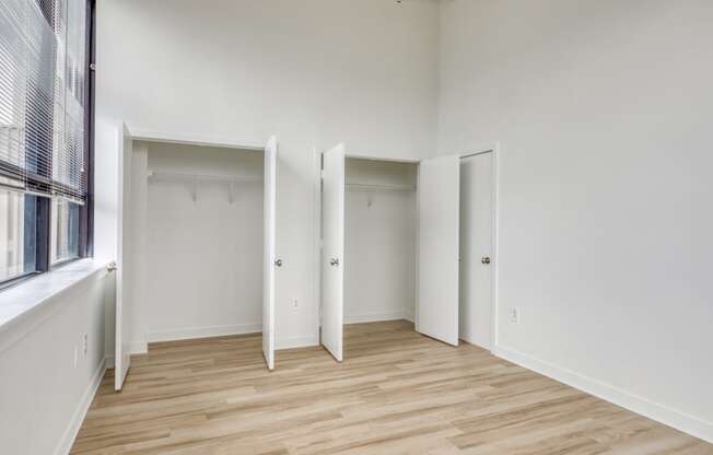 a bedroom with hardwood floors and white walls