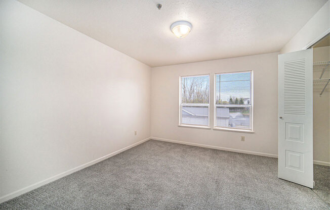 bedroom with a large window and walk-in closet  at Canal 2 Apartments, Lansing, 48917