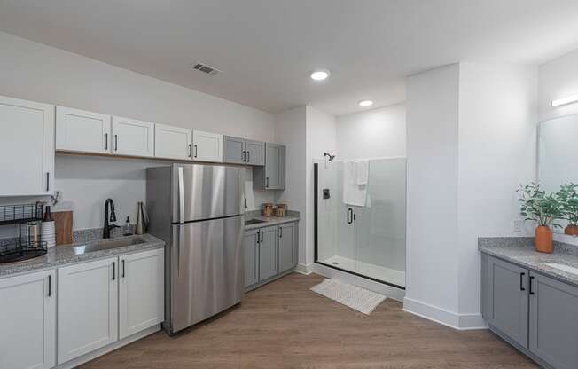 a kitchen with white cabinets and a stainless steel refrigerator