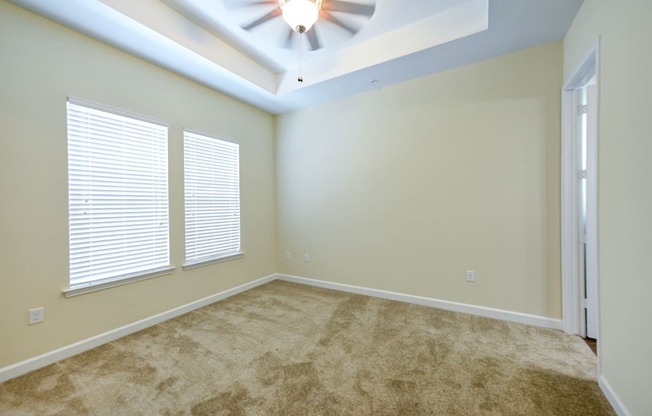 a bedroom with a ceiling fan and two windows  at Alaqua, Jacksonville, FL, 32258