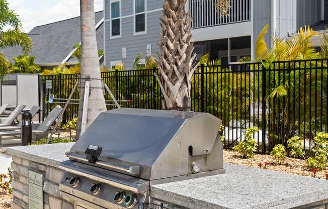 a stone barbecue grill in front of a house at Palm Grove in Ellenton, FL 34222