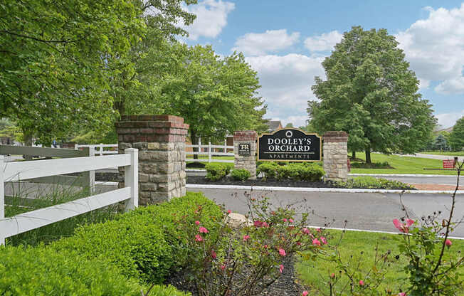 A sign for Dooley's Country Club is displayed in front of a white fence.