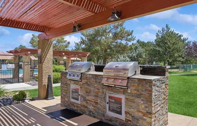A covered picnic area with a grill and a sign.