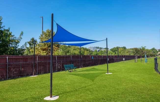 a park with a blue canopy and a bench