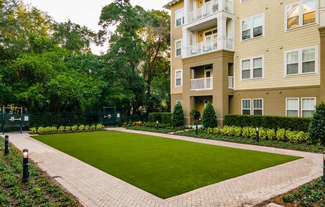 a green lawn in front of an apartment building
