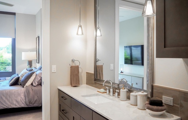 3 bedroom model private bathroom for third bedroom with a sink and a mirror at The Hamilton apartments in Dallas, TX