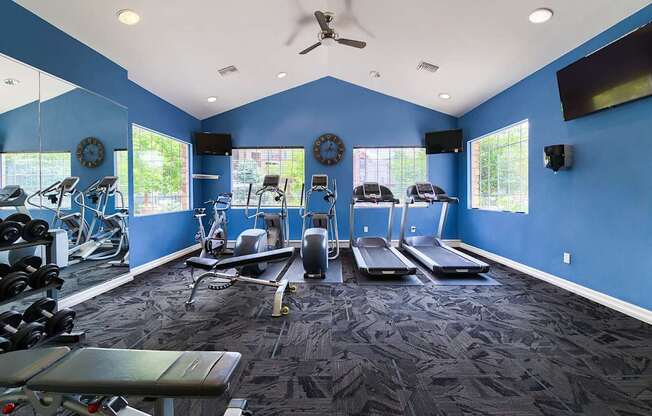 A spacious gym with a variety of equipment including treadmills, weights, and exercise machines.